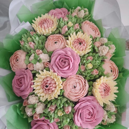 24 floral cupcake bouquet with pink roses, peach and cream buttercream flowers in green wrapping